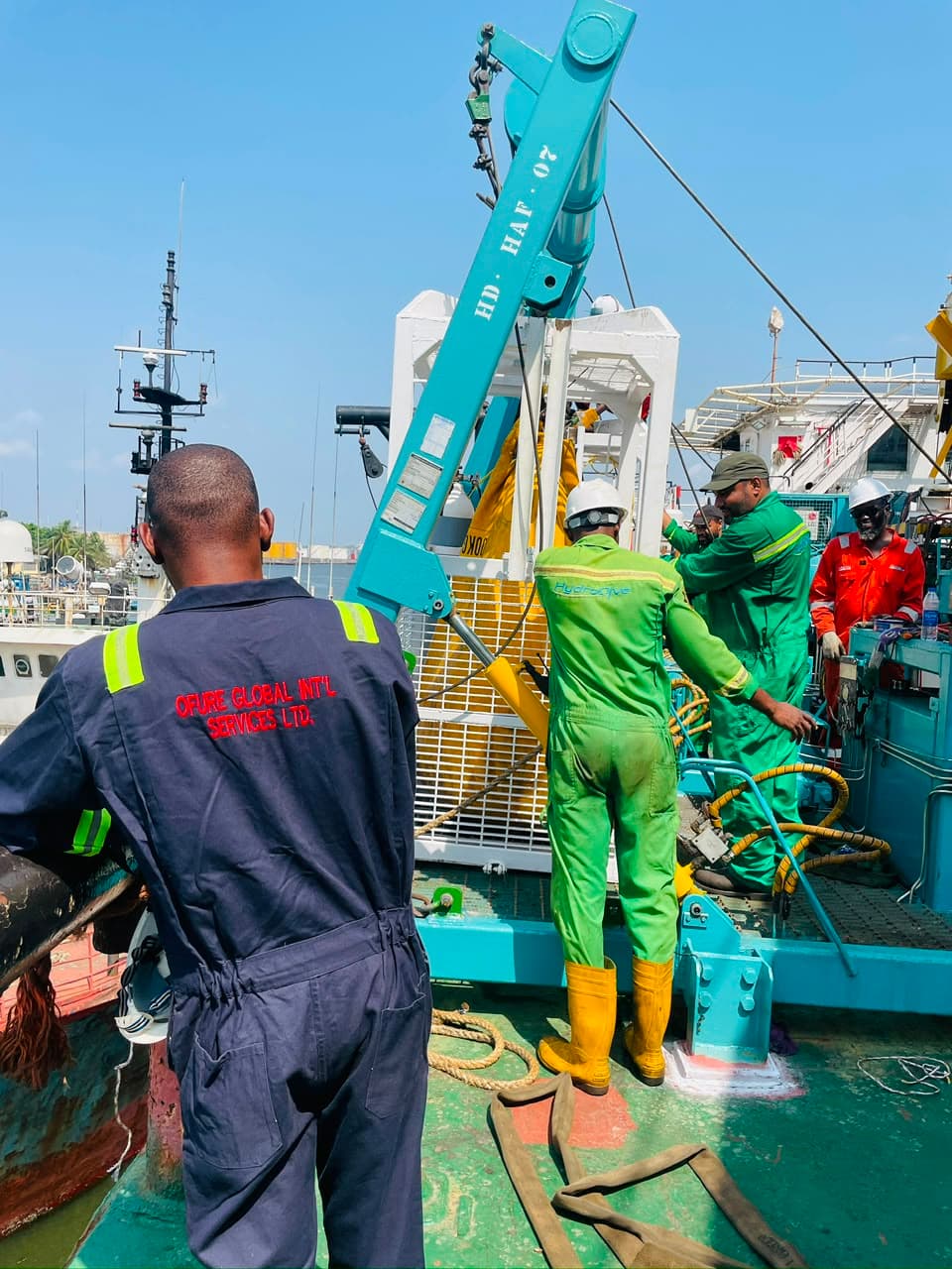 Personnel coordinating equipment on the deck of a marine vessel